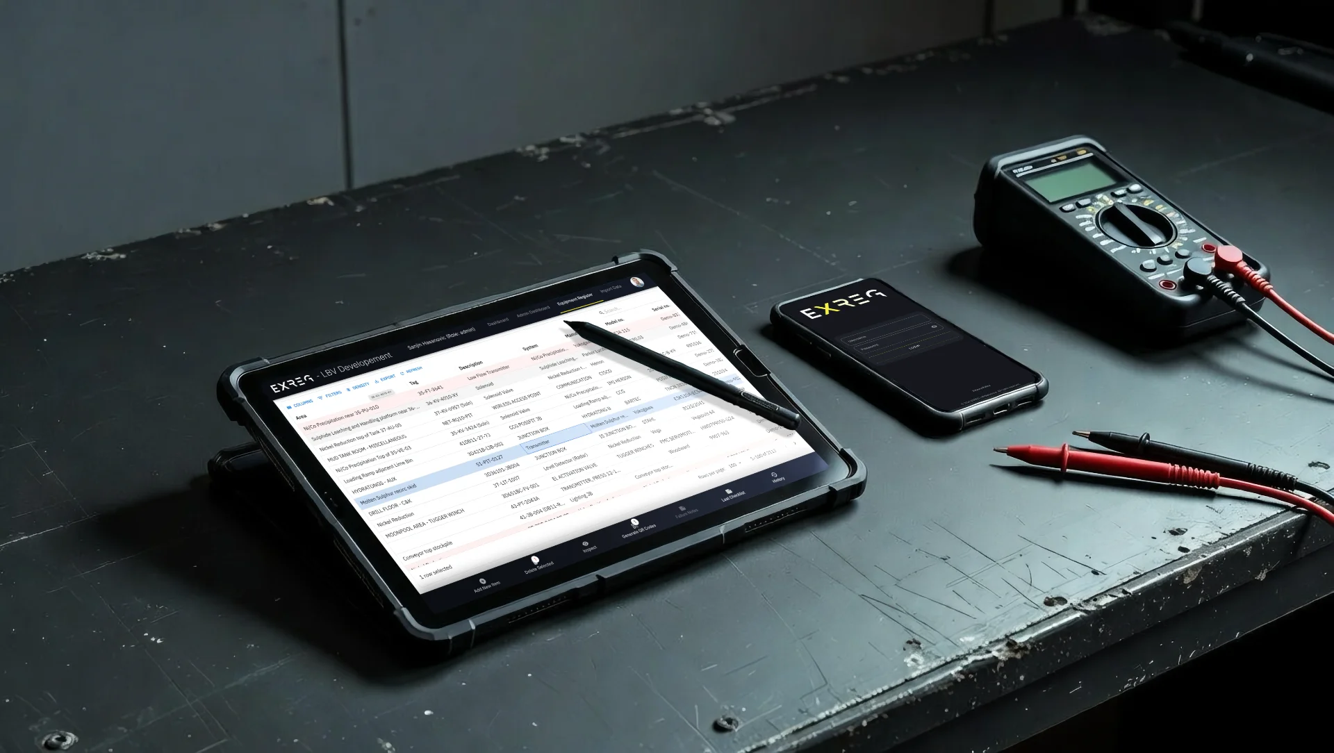 EXREG equipment register on a tablet and mobile phone alongside workshop instruments